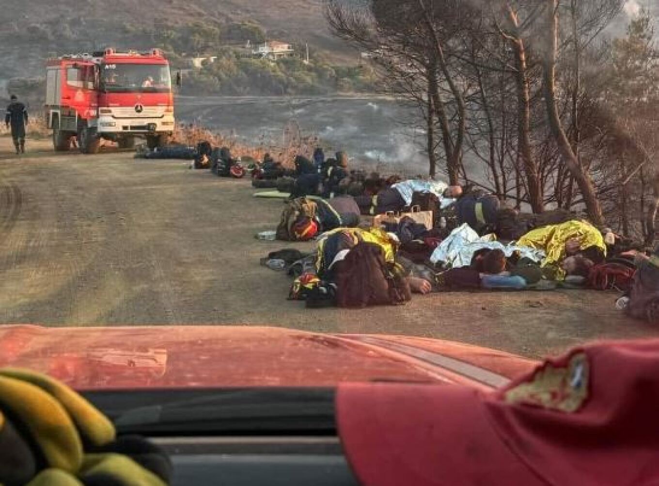 Εξαντλημένοι πυροσβέστες ξαπλωμένοι στο χώμα για να ξεκουραστούν από τη φωτιά στην Κερατέα - Η φωτογραφία που έχει γίνει viral